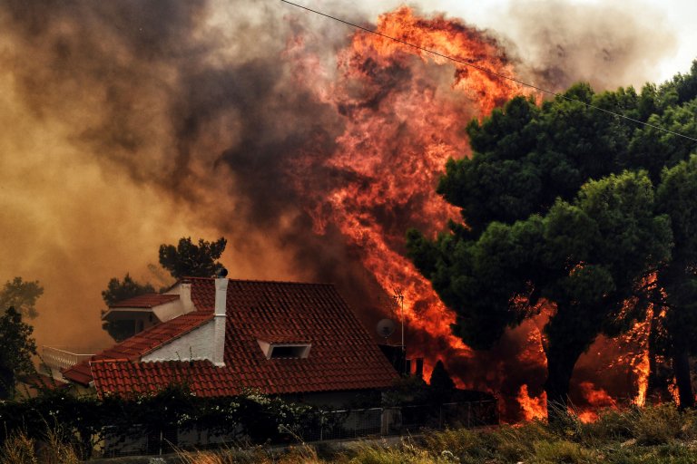 Towering flames consume trees and threaten a home in Greece