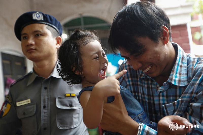 Detained Reuters journalist Kyaw Soe Oo plays with his daughter as he is escorted by police at Insein court in Yangon, Myanmar