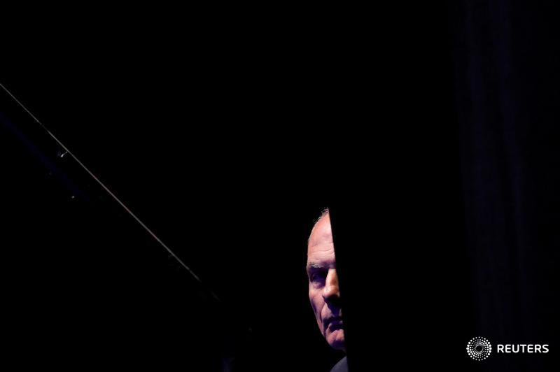 White House Chief of Staff John Kelly looks out from behind a curtain before President Trump addresses the Veterans of Foreign Wars' 119th VFW national convention in Kansas City, Missouri