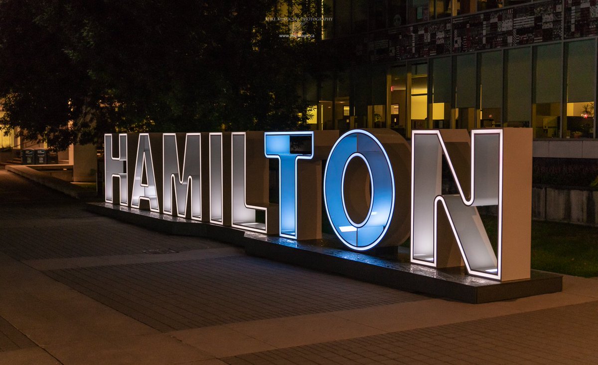 FredEisenberger's tweet photo. Flags at city hall are at half-staff and the Hamilton sign is being lit in blue and white highlighting the letters “TO” in Hamilton in support of #Toronto following the shooting on the #Danforth. #HamOnt https://t.co/2lBlqqal5U