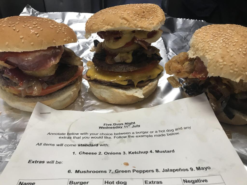Three stacked burgers, and an order form on foil
