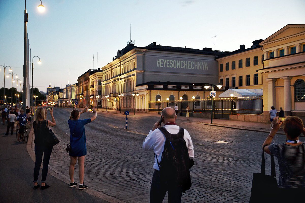 HRC’s message projected onto the side of the Presidential Palace in Helsinki, Finland, condemning Trump-Putin's silence on the human rights atrocities happening in Chechnya.