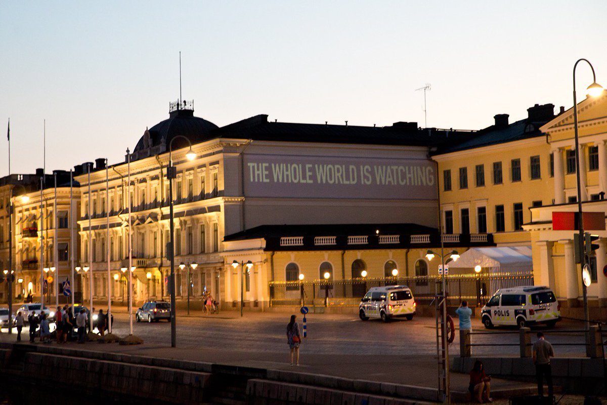 HRC’s message projected onto the side of the Presidential Palace in Helsinki, Finland, condemning Trump-Putin's silence on the human rights atrocities happening in Chechnya.