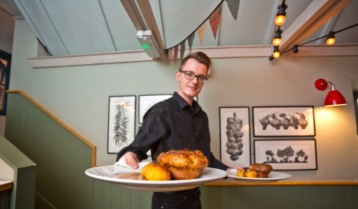 A waiter serves dinner at the The Hop Pole in Bath, England