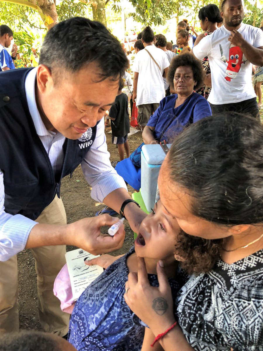 Dr Luo Dapeng administers the oral polio vaccine to a child in PNG