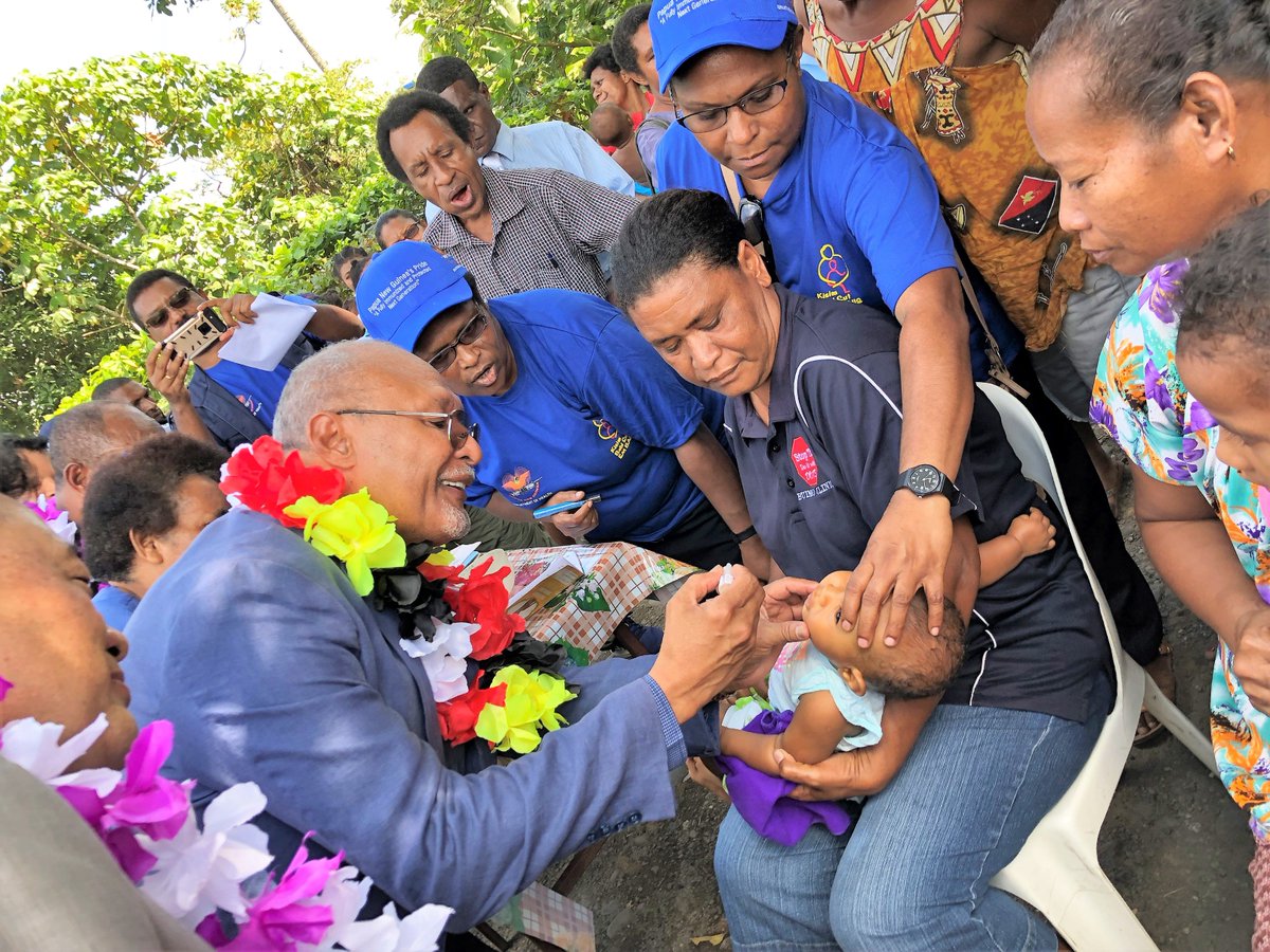The Honorable Puka Temu, Minister of Health Papua New Guinea, administers the oral polio vaccine (OPV) to a child during the launch of the polio vaccination campaign