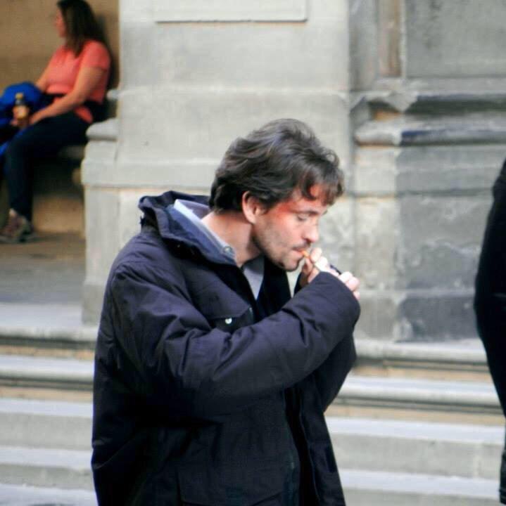 Hugh Dancy pali papierosa (lub trawkę)

