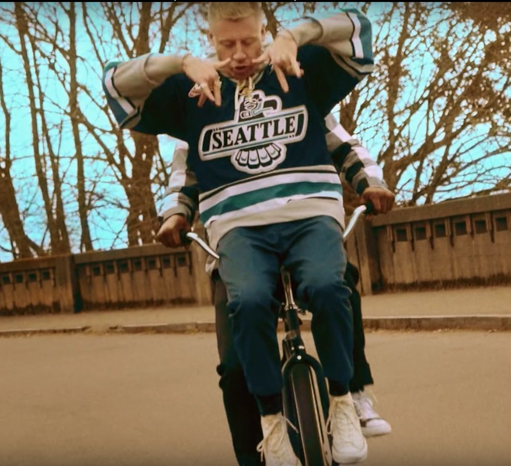 SeattleTbirds's tweet photo. Hey @macklemore, You're looking awesome wearing our jersey in "How To Play The Flute" music video. You wanna wear that jersey at our Home Opener Sept. 22 and drop the ceremonial first puck? We're playing @pdxwinterhawks and it would be Glorious to have you at @ShoWareCenter. https://t.co/UPCLbYSOEd