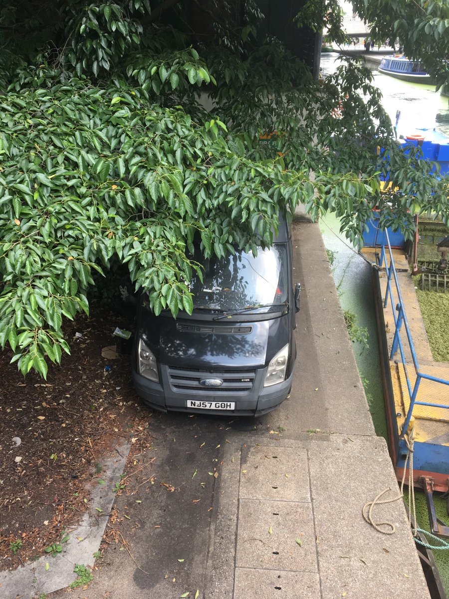 Garda920's tweet photo. @MetCC there’s what looks like a stolen black transit van under trees along the canal side In Paddington. Quarter light broken. Ignition looks damaged. On the opposite bank to Sheldon Square W2. Certainly suspicious https://t.co/uOE0kqyusw