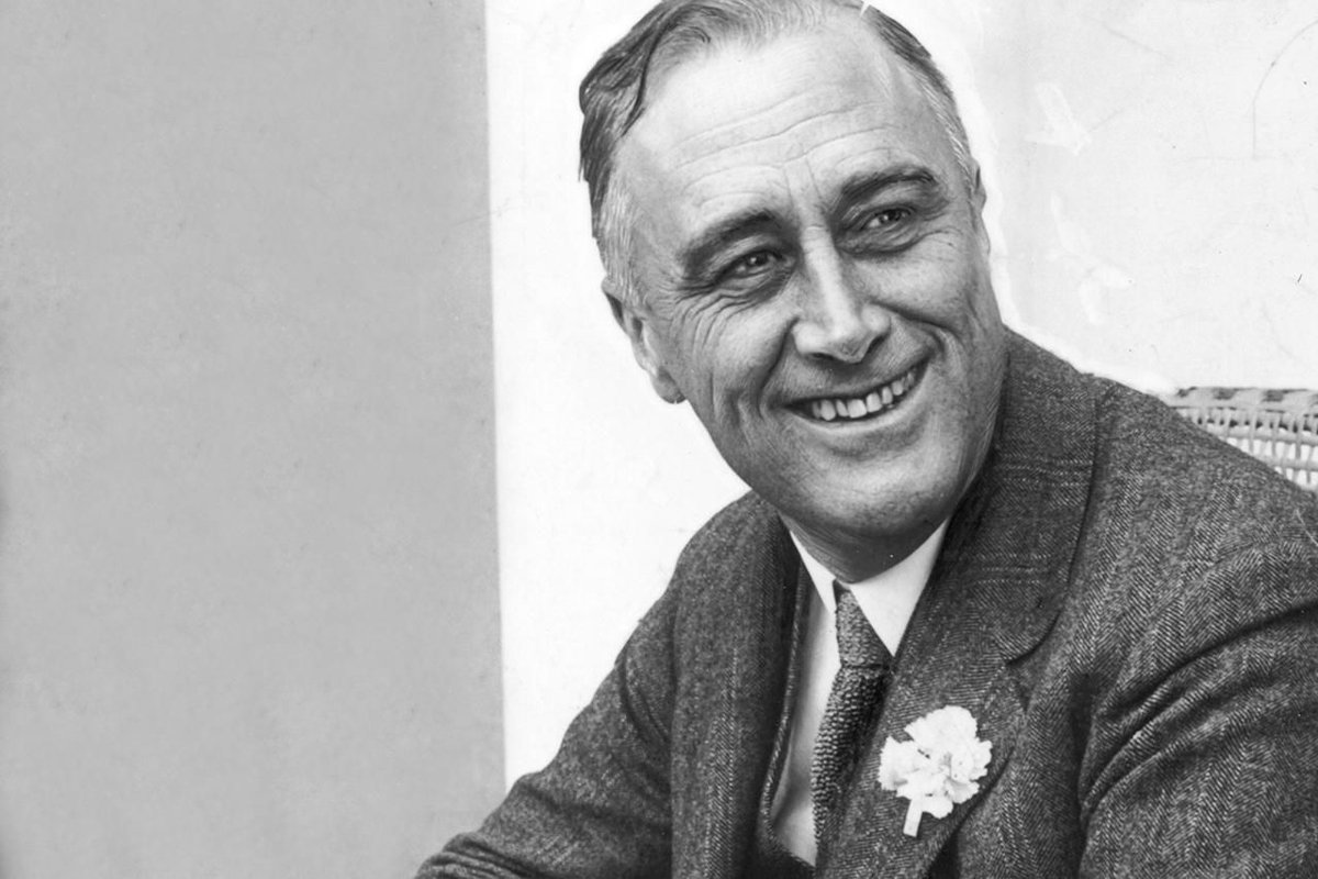 Black and white photo of Franklin D. Roosevelt smiling.
