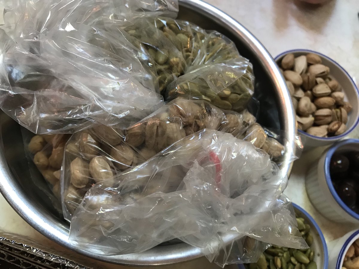 A bowl with bags full of pistachios, pumpkin seeds, etc.