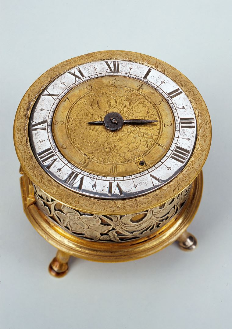 Circular table clock with alarm, Edward East, c 1640.  The silver chapter ring surrounds the floral engraved gilt alarm disc, but the silver band around the case drum is a replacement – perhaps the original was cut off and melted down as Civil War ensued? 
#TableClock #Bonhams