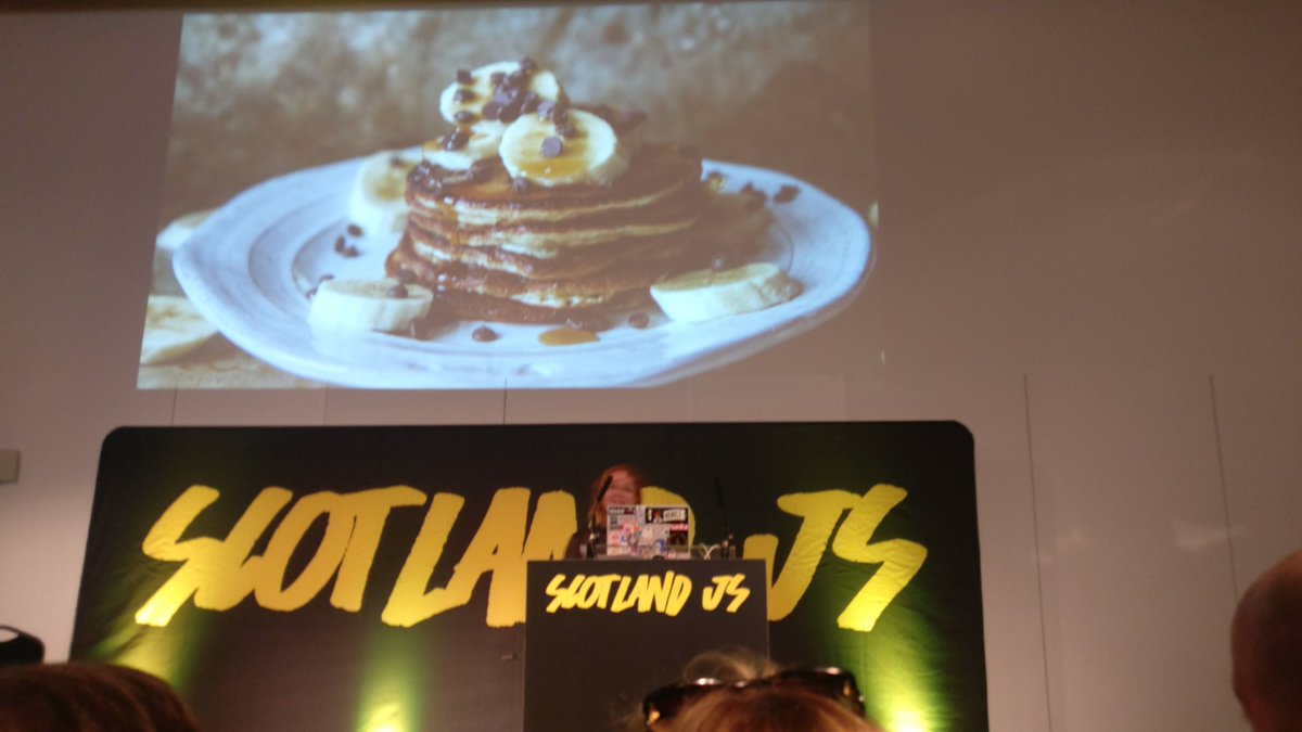 Ola on stage with a slide of a stack of chocolate chip pancakes
