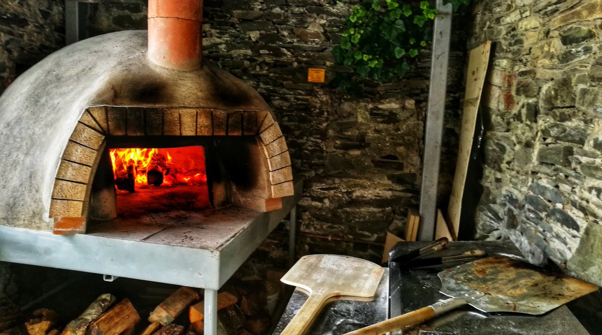 Wood-fired pizza oven in stone-walled courtyard