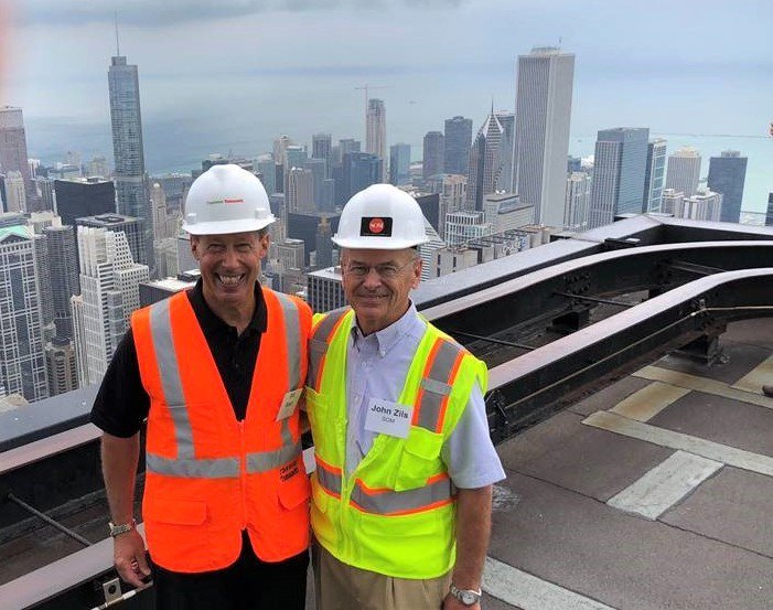 william_bast's tweet photo. Mentor John Zils (right) and mentee connected via #SearsTower/#WillisTower: a 50 year journey from #SOM's design in 1969 to #TTInc design in 2018. Photo from the 90th floor roof during this morning's #AISC staff and friends tour of the Willis Tower Repositioning project. https://t.co/nPndQQZnwA