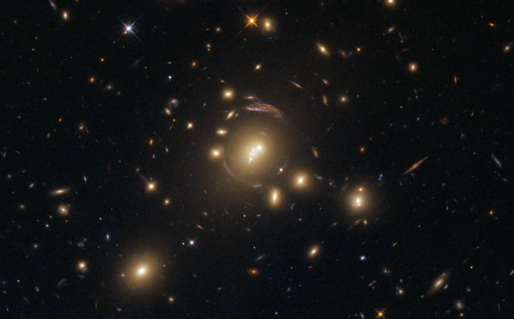 A cosmic phenomenon known as strong gravitational lensing is the cause of the mind-bending distortions seen in this <a href="/NASAHubble/">Hubble</a> image. The gravitational influence of the bright galaxy cluster at the center, warps the very shape &amp; fabric of its environment: go.nasa.gov/2LeIFnu