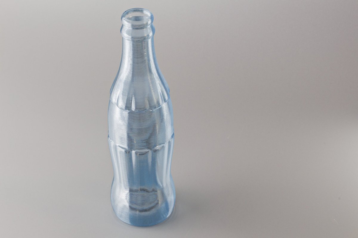 hotnozzle's tweet photo. Bottle modeled in #Blender, printed on @Ultimaker 2 w/ 1mm nozzle using @Fillamentum/@FilamentOne Crystal Clear Iceland Blue PLA and Cura's spiralize/vase mode. https://t.co/pMmw8UoGA9 https://t.co/HBoPTlWYup