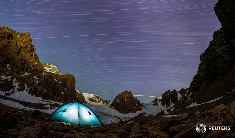 A long exposure picture shows stars and meteor trails above the mountains of Tien Shan in Kazakhstan