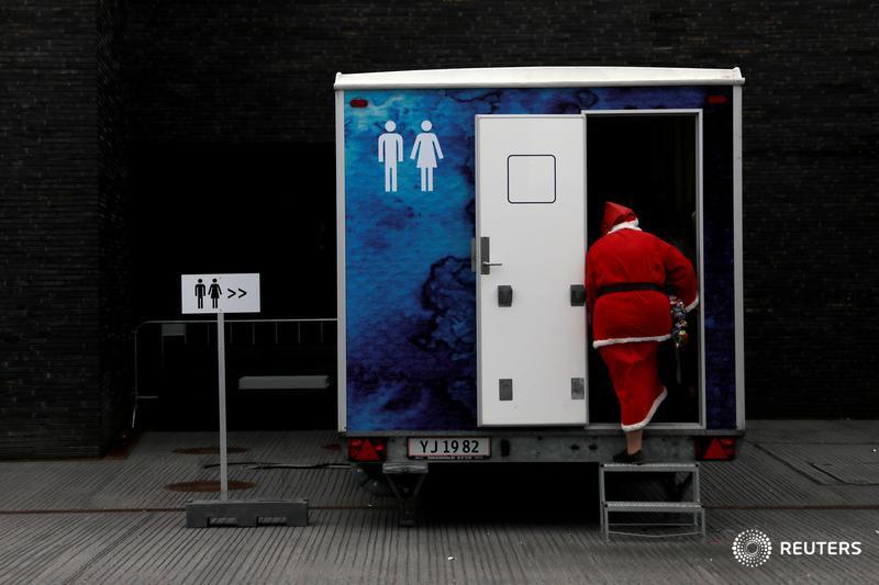 A person dressed as Santa Claus uses a restroom during the World Santa Claus Congress, an annual event held every summer in Copenhagen, Denmark