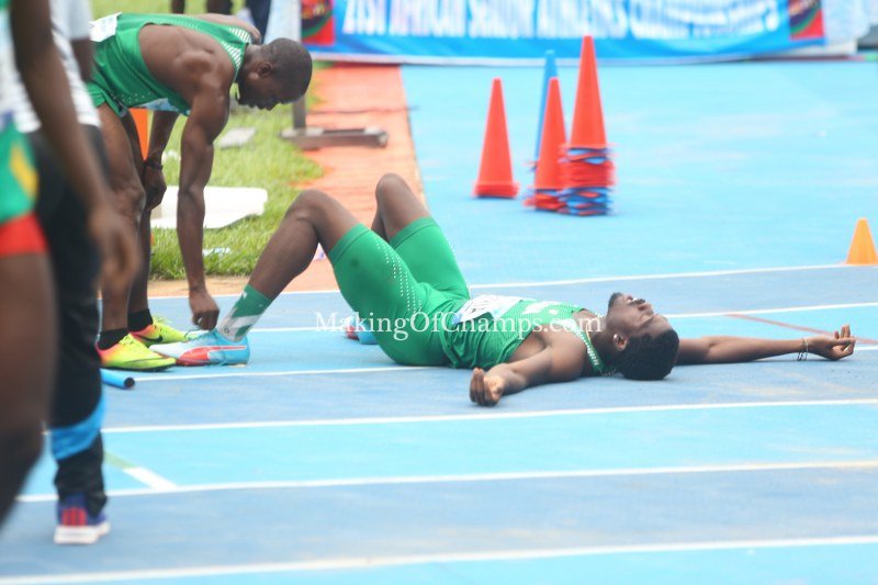 MakingOfChamps's tweet image. An exhausted Chidi Okezie being helped by his teammate, Orukpe Erayokan to untie his spikes after giving his all to ensure that Nigeria finished on the podium in the men's 4x400m. Kenya won the GOLD, and South Africa Silver, with Nigeria taking the Bronze medal #Asaba2018