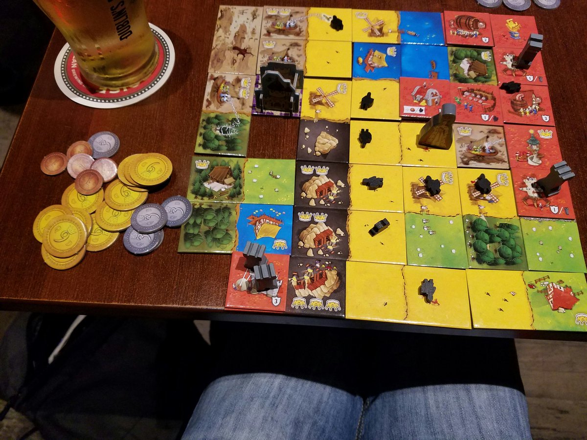 A completed game of Queendomino, with a stash of coins next to it)