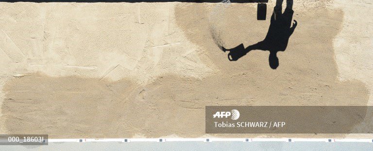 A volunteer waters a sandpit ahead of the #2018EuropeanAthleticsChampionships in #Berlin on August 6, 2018. #AFPphoto #AFP