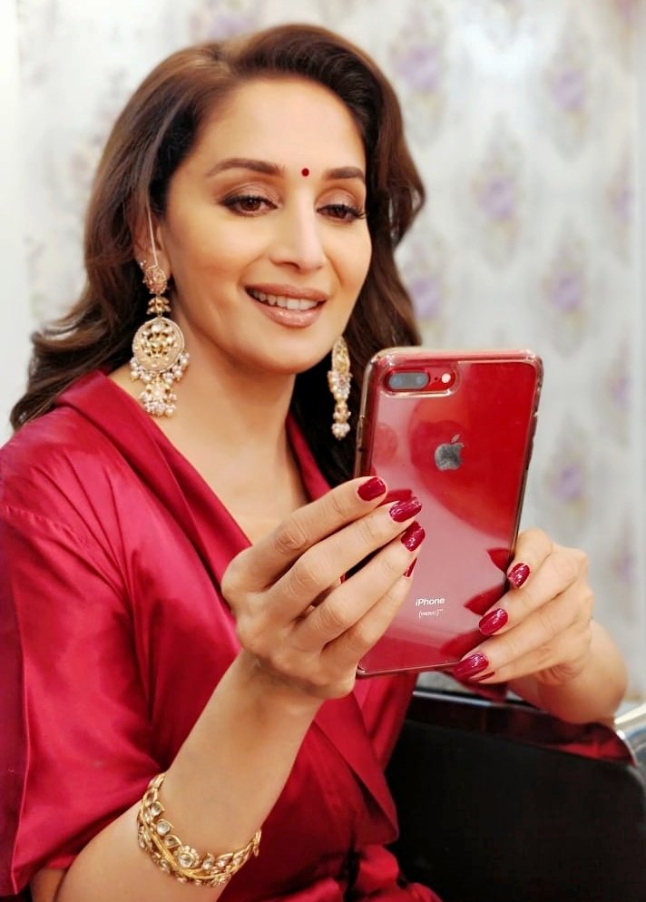 MadhuriDixit's tweet photo. Color coordinating! ❤ 
It's wonderful to know that each sale of #iPhone8plusRED adds to the global AIDS eradication initiative 🙌 https://t.co/fUN9h0Hkhy