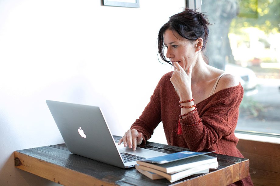 woman looking at her laptop sitting down