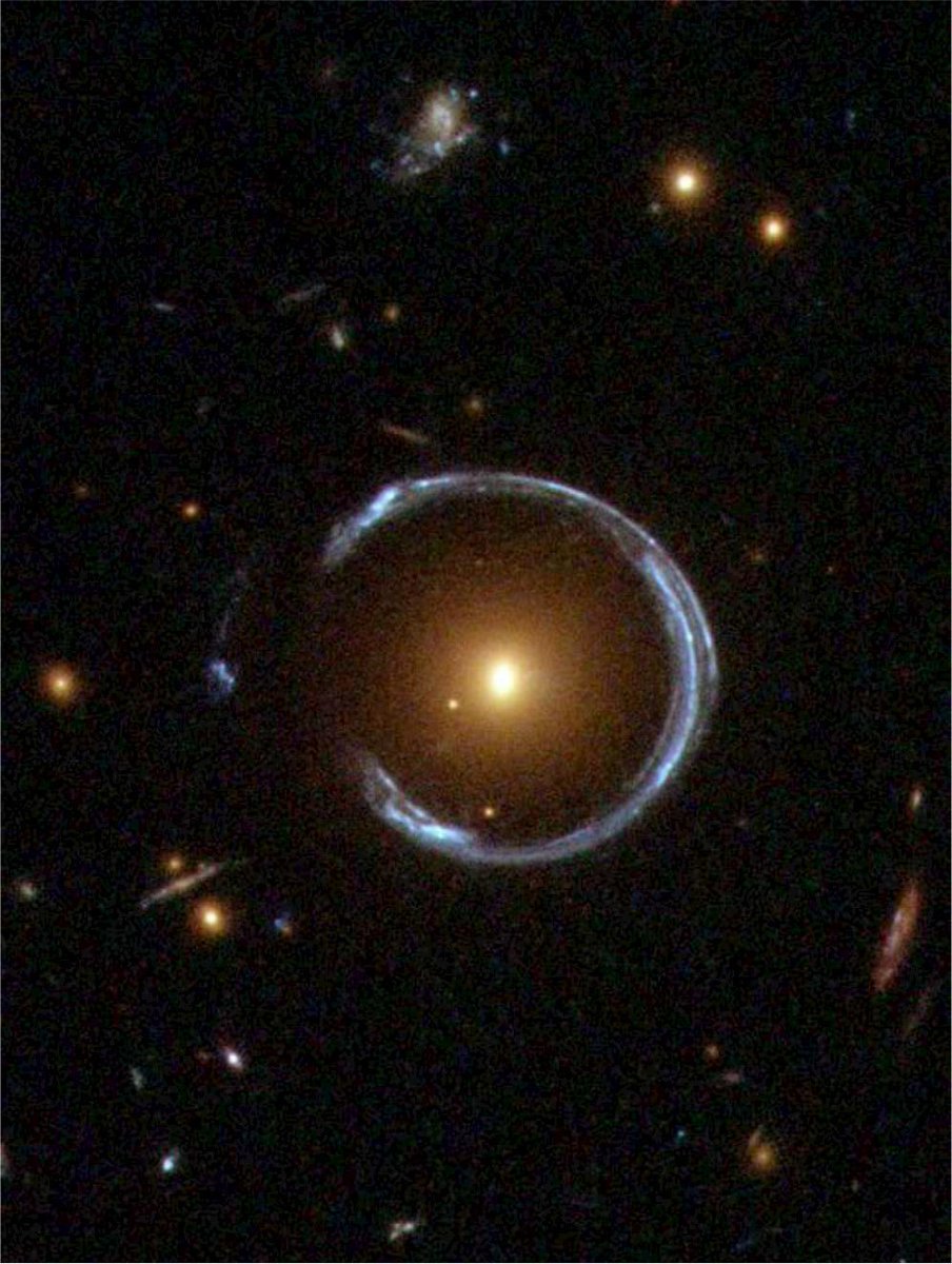 So, if there's a galaxy behind a large mass (ex, large elliptical galaxy), you'll see warped images of that galaxy around that mass. And the amount that the image is warped tells us how much mass there is in the foreground galaxy! (Image LRG 3-757, cred NASA/ESA/Hubble)