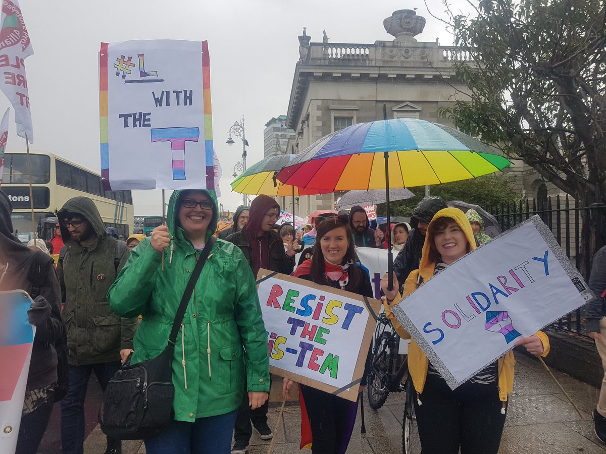 A group of protesters show solidarity with a #LwithteT sign