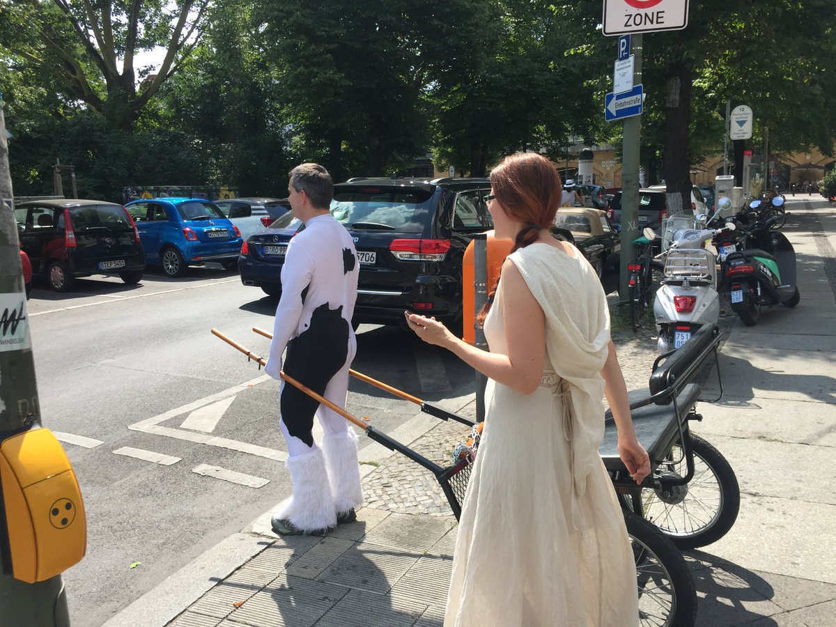 You see weird stuff in Berlin. At first I thought the guy was dressed as a cow but his feet suggest a Clydesdale horse. How the woman’s costume and the cart fit in, no clue. Any suggestions for a story that explains this?