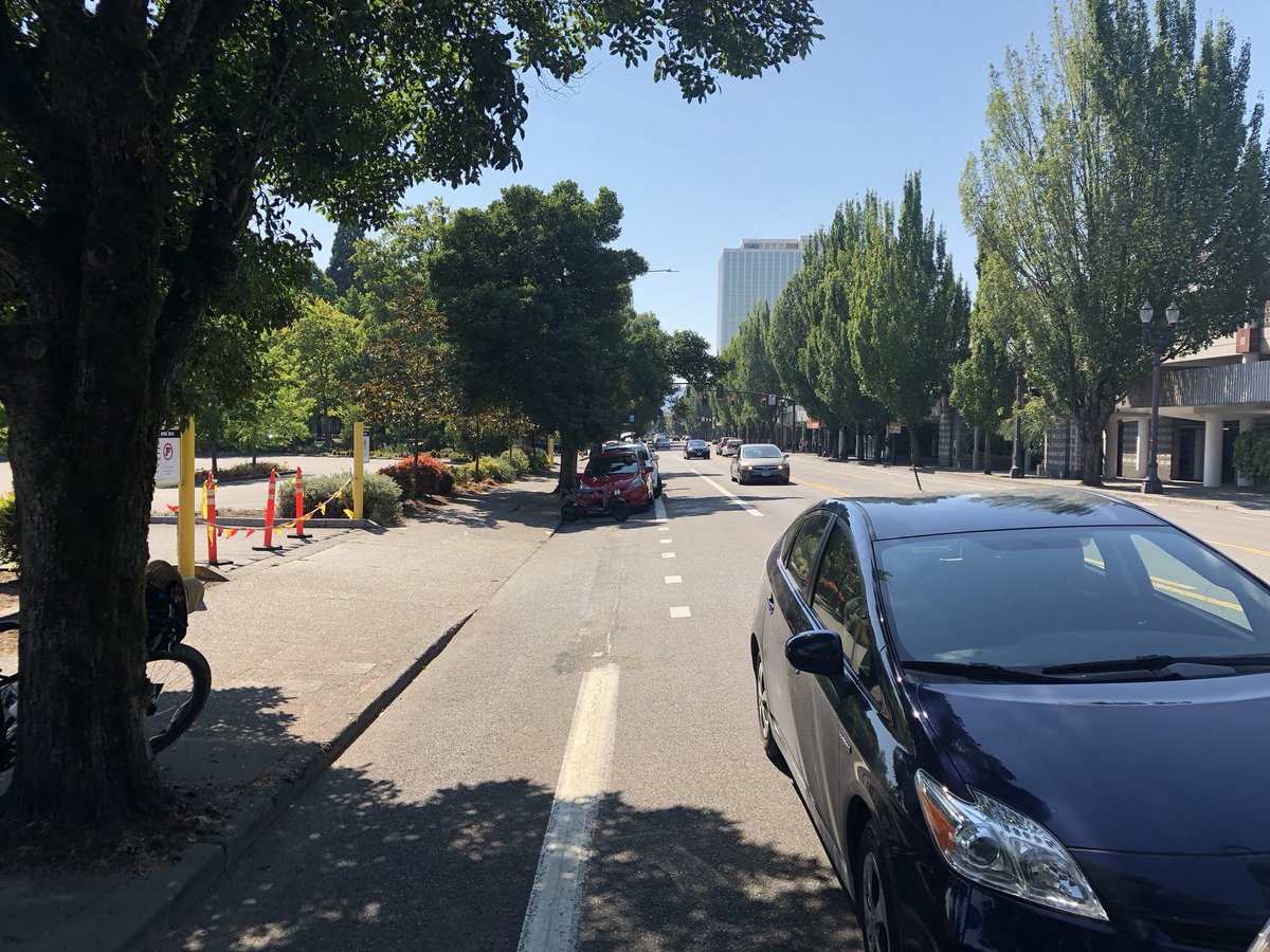 Eric_Ivy's tweet photo. There’s a half block of illegally parked cars on NE Multnomah by Lloyd center that need to be ticketed and towed. I’m too hot to be doing this. @PortlandPolice @PBOTactive @PBOTinfo your lackluster lanes and signage let this happen. @BikePortland https://t.co/0ghmVJRG6H