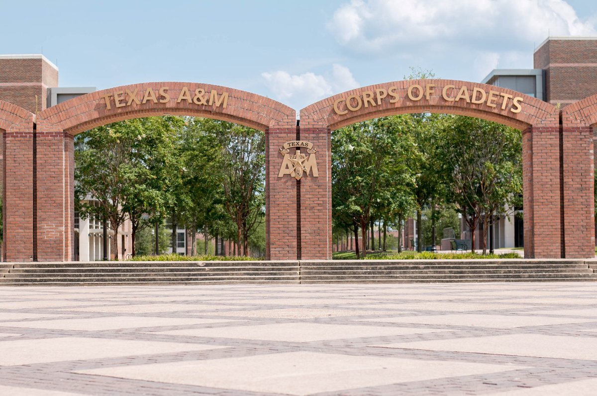 Looking at the corps arches on a sunny day with trees, dorms, and the quad behind them