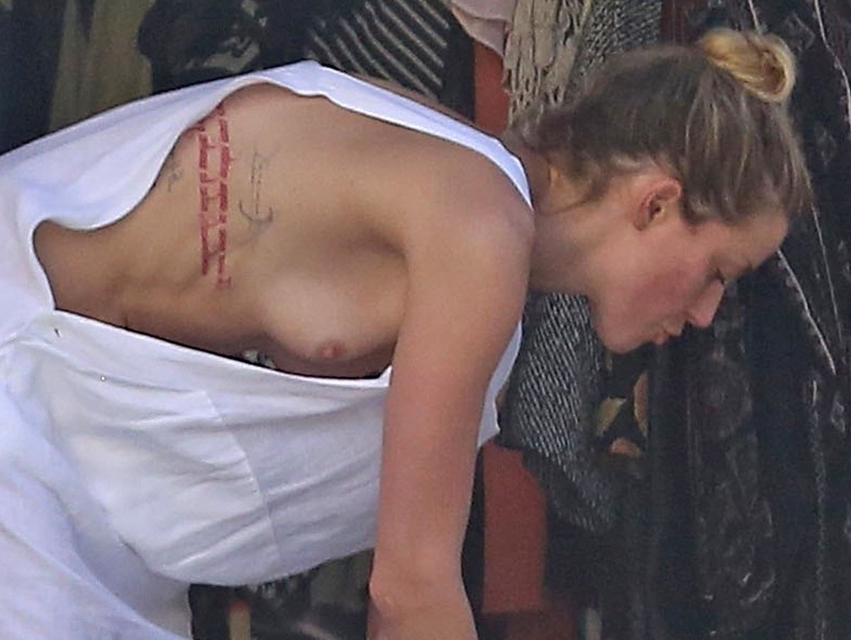 Amber Heard braless boobs pop out nip slip while cleaning out her garage in...