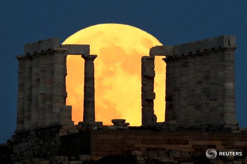 A full moon rises behind the Temple of Poseidon before a lunar eclipse in Greece