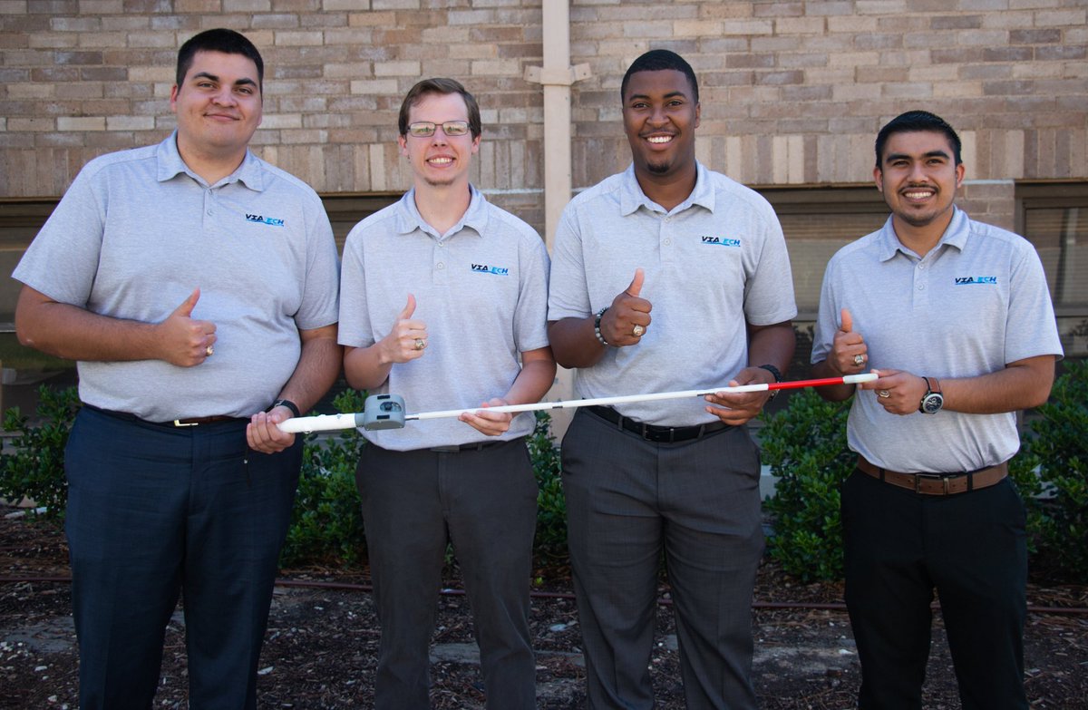 four students with thumbs up holding a walking cane with their attachment
