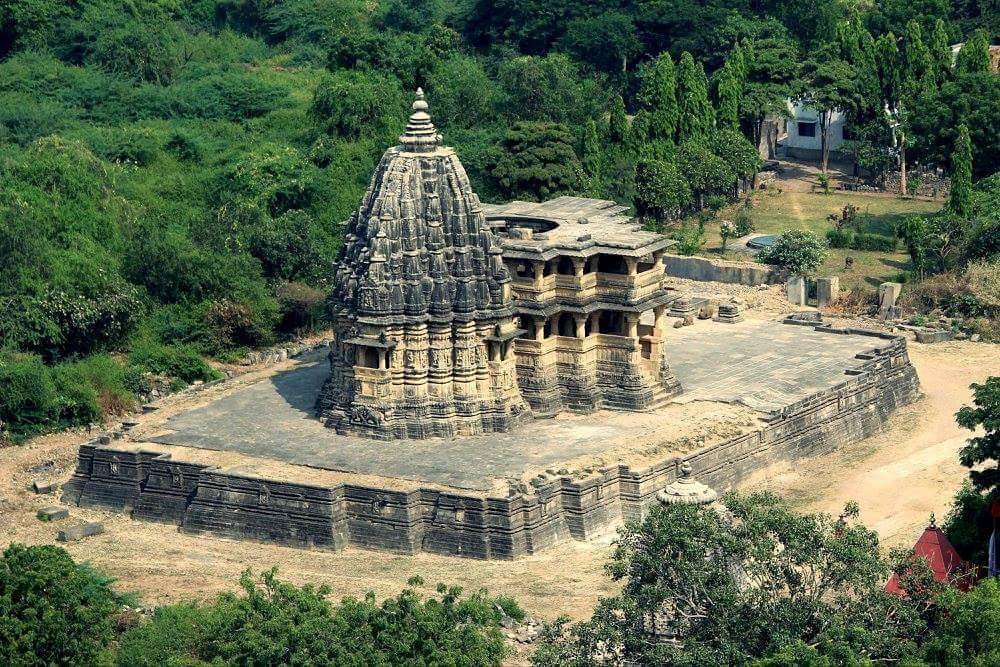 Distant view of same NauLakha Temple in Ghumli, Porbandar(Gujrat)The Mandapa of the temple follows cruciform plan and have 22 regular columns and 30short columns on low screen wall. Brackets are adorned with Kirtimukha, Hamsa etc. Dome was already ruined when Burgess reported.
