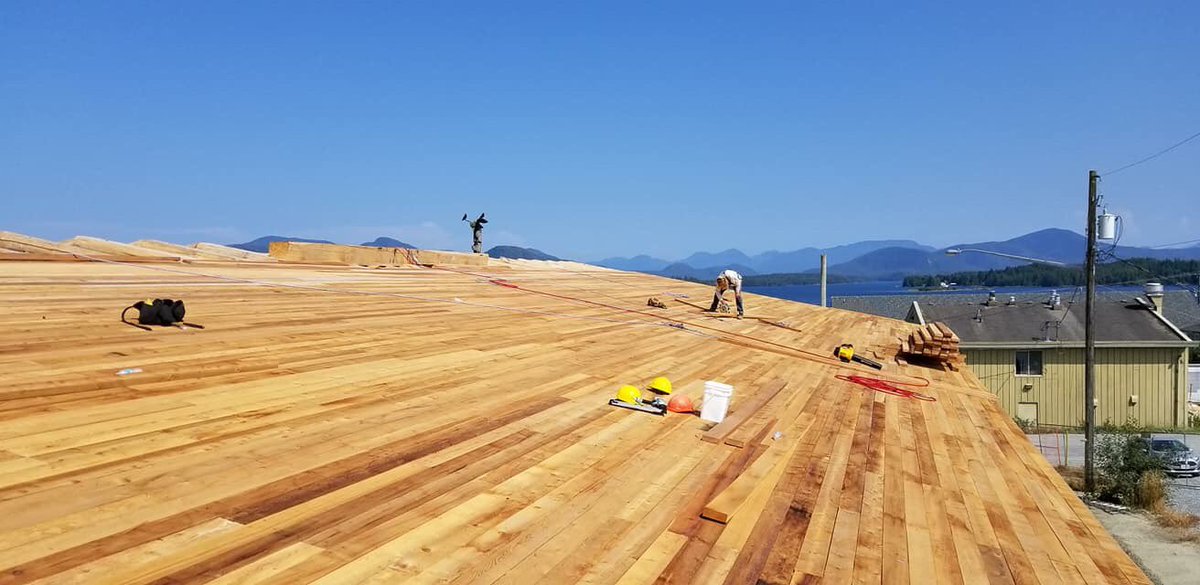 HeiltsukBH's tweet photo. The north side of the #HaíłzaqvBighouse now has half a roof, and the south side is already done. The goal is to have the house tightened up before the fall weather sets in! Photo Credit: Eddie Jones https://t.co/iA8SwhyuO7