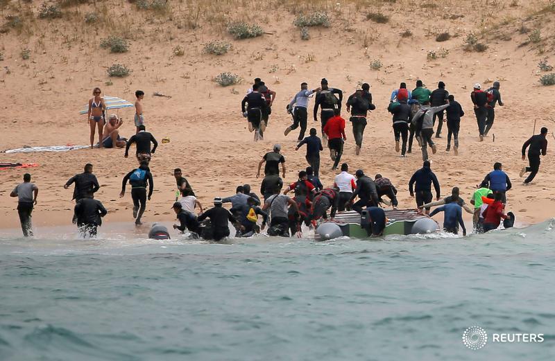 Migrants disembark from a dinghy at 'Del Canuelo' beach after they crossed the Strait of Gibraltar from Morocco to Tarifa, Spain