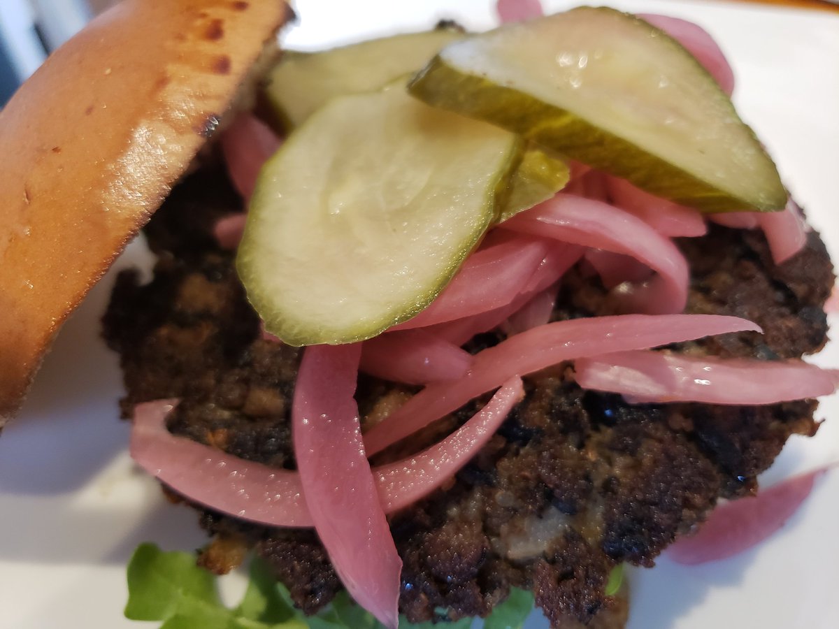 Our homemade pickles and pickled onions atop our black bean and quinoa burger made from scratch.  What a combo!