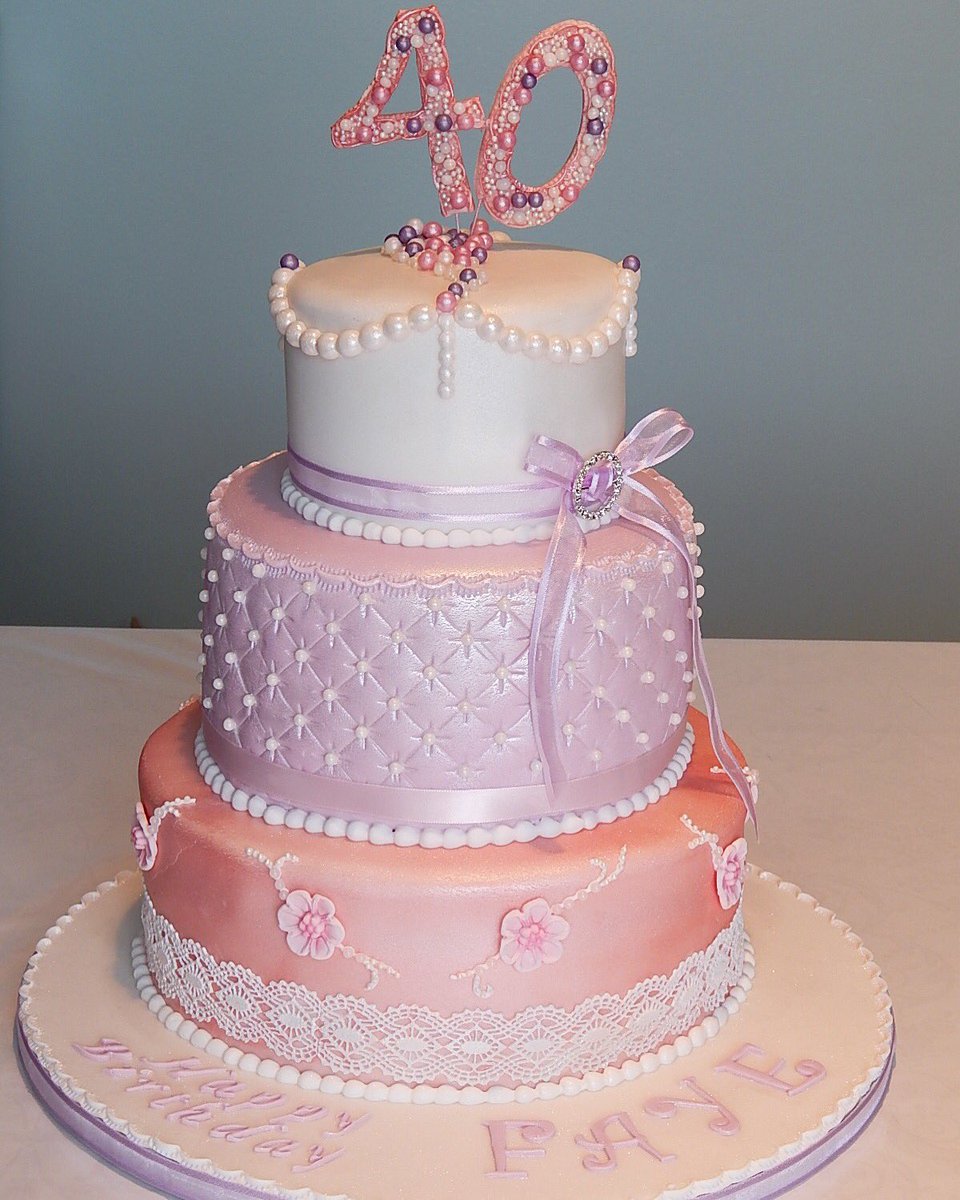 A vintage-themed pastel #cake.
Handmade blossoms, cake lace and pearl effect swags attached to lustre finished tiers. 
Top tier: Lemon sponge with lemon curd.
Middle tier: Red velvet with dark chocolate.
Bottom tier: Victoria sponge with vanilla buttercream &amp; strawberry conserve.