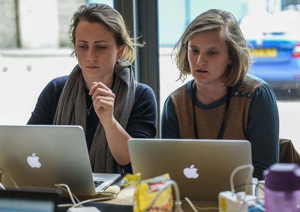 Two woman concentrate whilst on laptops. Photo credit: Orquidea Real Photobook - Julieta Sarmiento Photography
