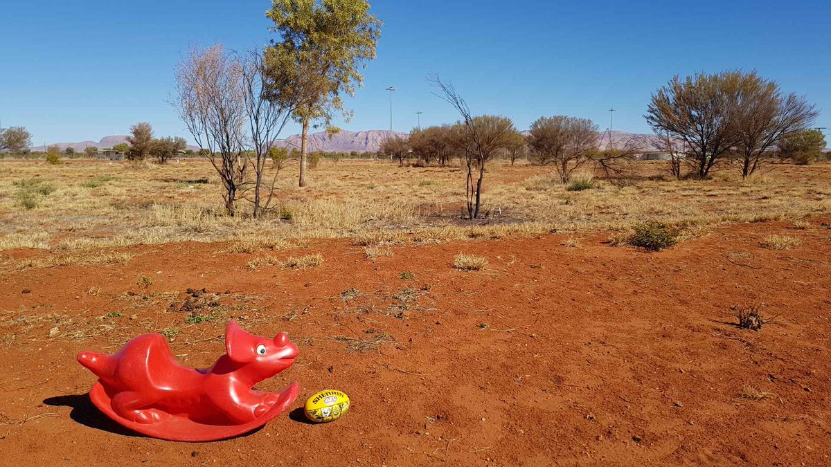 WaltjaPalya's tweet photo. This little #RedDinosaur was kindly donated to Waltja and he's enjoying the road trip to find a new family. Here he is en-route to Mt Liebig playing a spot of footy. The country out West of Alice Springs is beautiful - red dirt, blue sky, golden spinifex, purple mountains.. https://t.co/Df6hZu7cqU