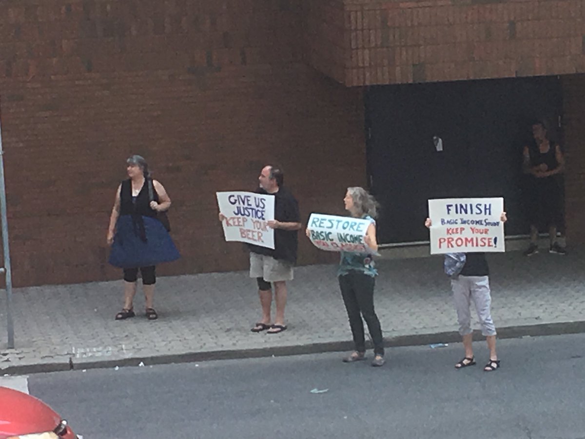 basicincomeHAM's tweet photo. Protesters outside Ellen Fairclough building in #HamOnt rally against #ONbasicincome pilot termination and cuts to social assistance https://t.co/Og7VT9PI4c