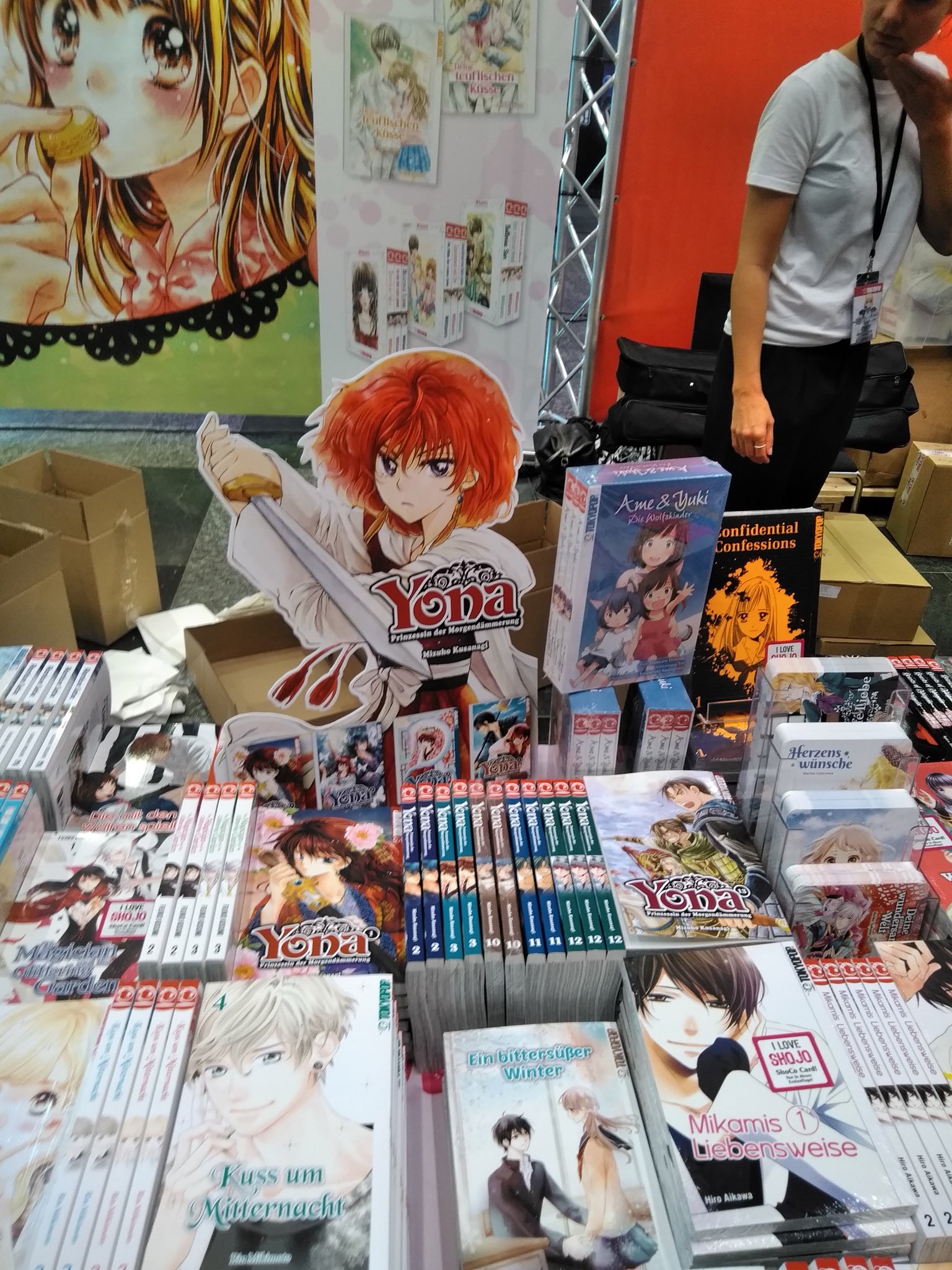 草凪みずほ 担当さんがドイツで開催された 日本の漫画アニメゲームのイベントに参加してきて 出版社ブースで販売されてたヨナです って写真2枚送ってくれました ドイツのヨナブースどうかしてる ってなったけど ブースは2枚目だったね ドイツ
