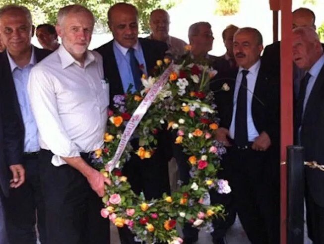 CorbynSnap's tweet photo. Please! Can we all look at this picture and establish FACTS: 
1. I did not touch the wreath
2. I did not carry the wreath
3. I am not at the location with the red supports described. 
4. I am not in the photograph https://t.co/vExWLPlWsn