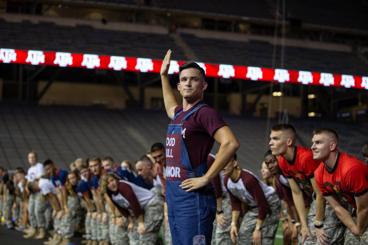 A yell leader with his arm up to his side leading a yell