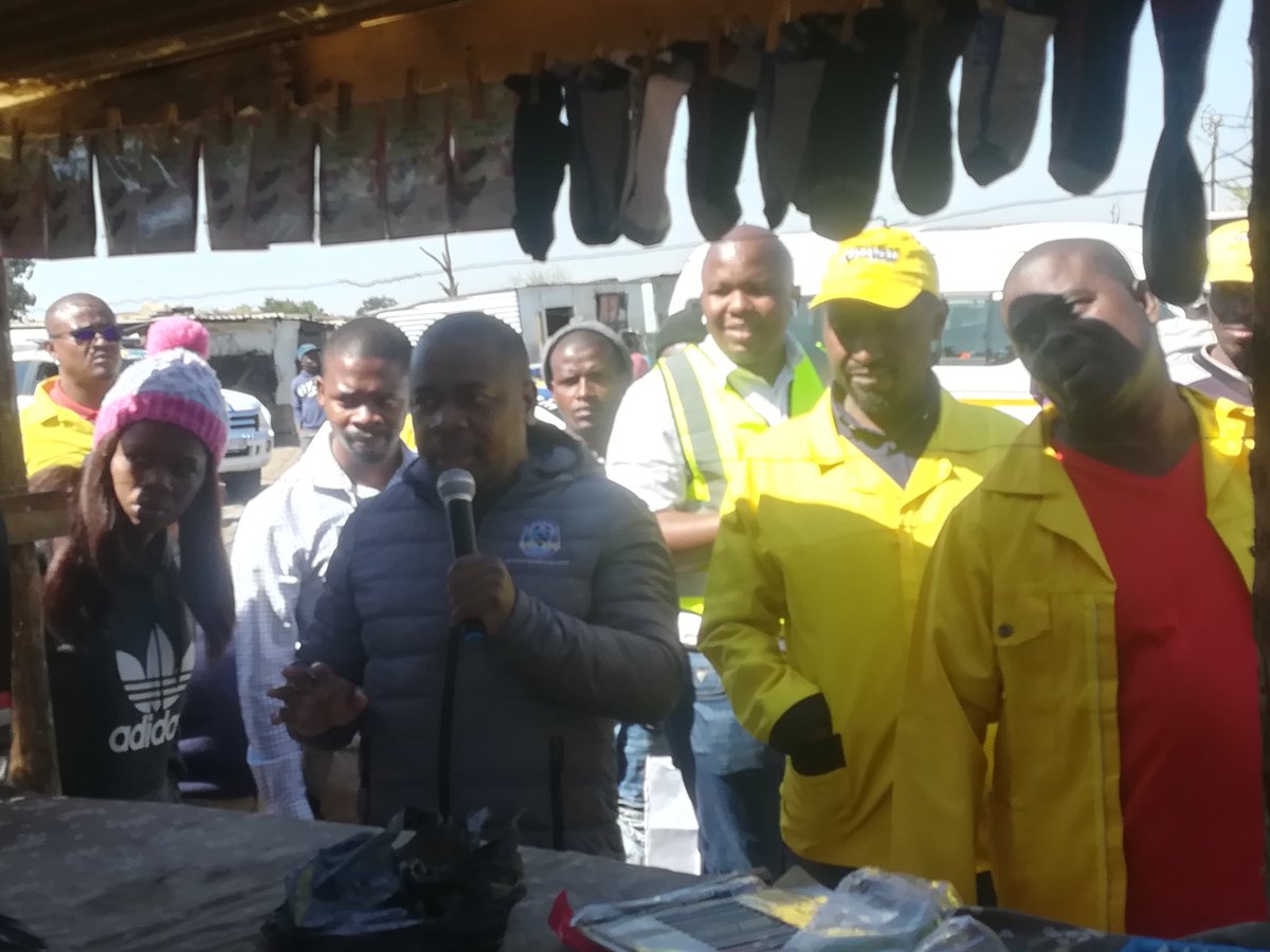 City_Ekurhuleni's tweet image. Executive Mayor @mzwandileMasina at a counterfeit goods stall, challenges owner (red jacket) to stop selling such stuff; EMPD  will remove the counterfeit stock. #CoESiyaqhuba #fakefoodcrackdown #CoEfakefoodcrackdown