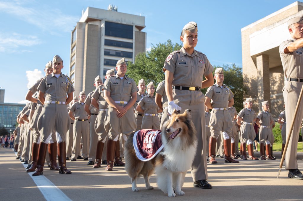 Reveille standing with her handler and cadets behind them