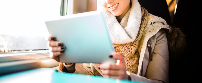 a woman smiling holding a tablet